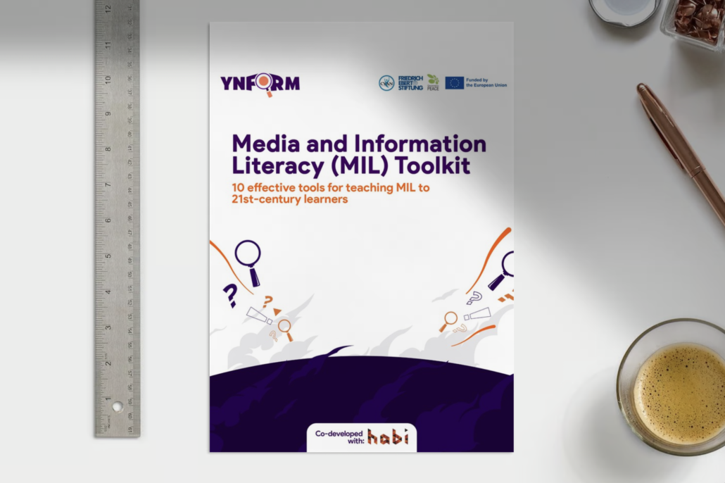 Cover page of the MIL Toolkit on top of a working desk
